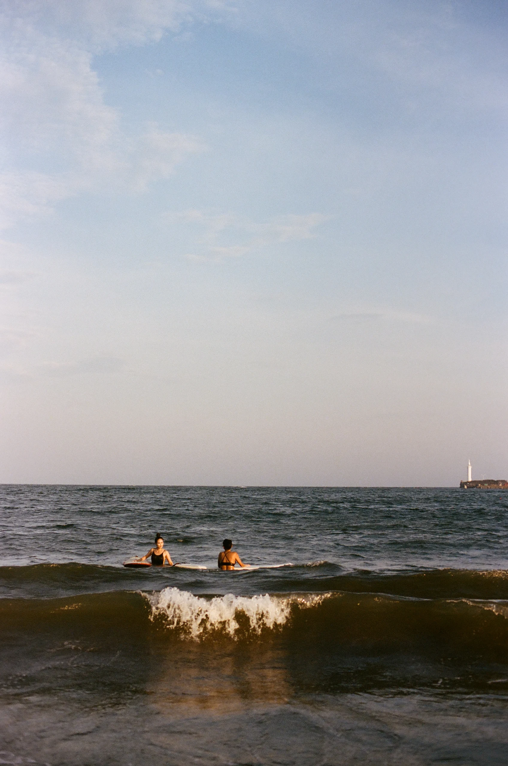 Two people enjoying the waves with their surfboards. Two people enjoying the waves with their surfboards